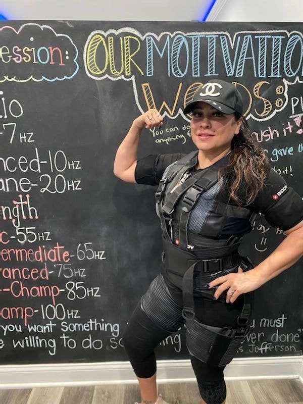 Woman in athletic gear at fitness chalkboard with motivation