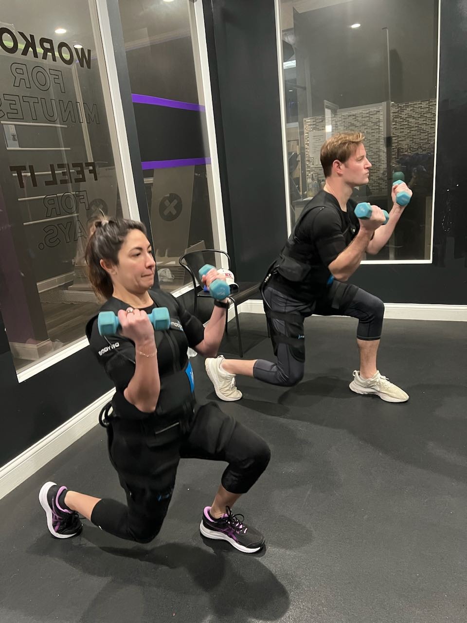 Certified coach guiding a client through an EMS training session at Meda-Fit